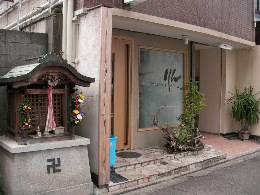 Buddhist—NOT Nazi—small shrine next to a new store front